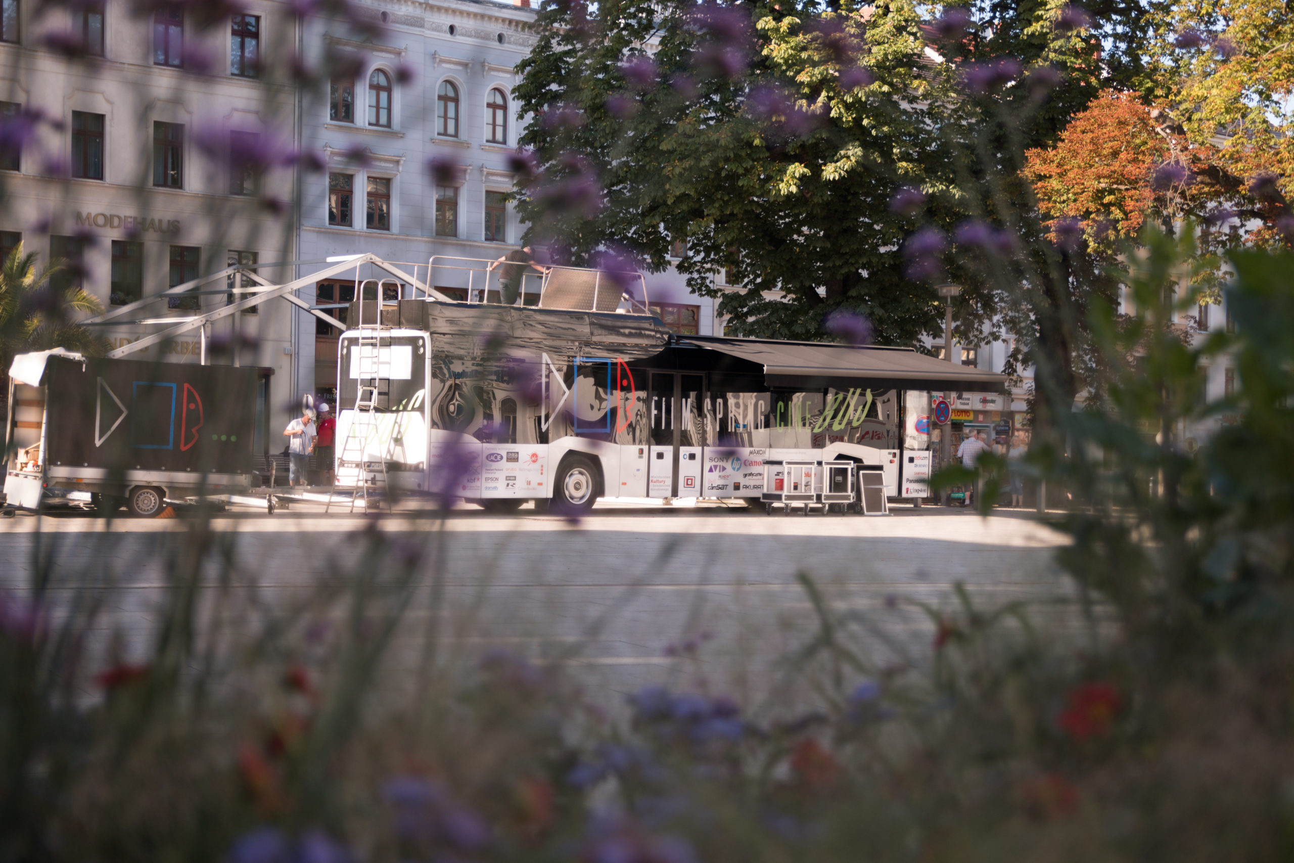 Cinebus zaparkowany na rynku w Goerlitz widziany przez kwiaty